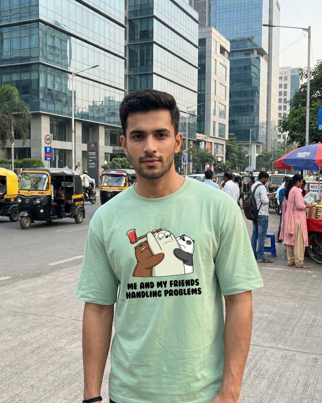 Man wearing a light green t-shirt with cartoon characters and text on a city street.